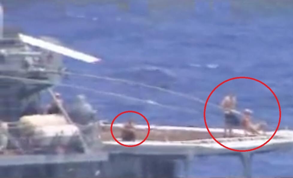 Shirtless Russian sailors casually sunbathe during a Near-collision between U.S. and Russian warships